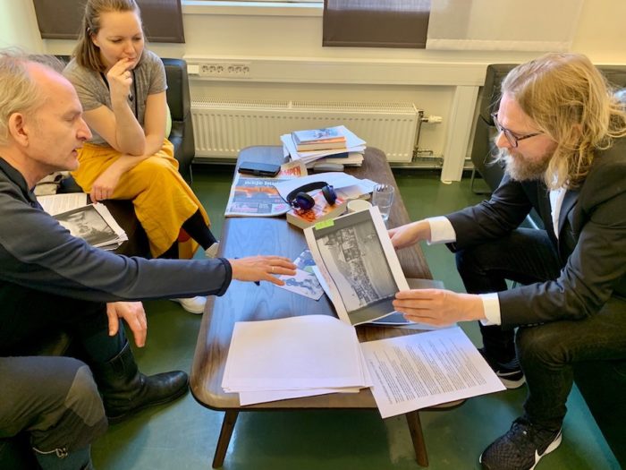 Tre personer i et møte, diskuterer bilder