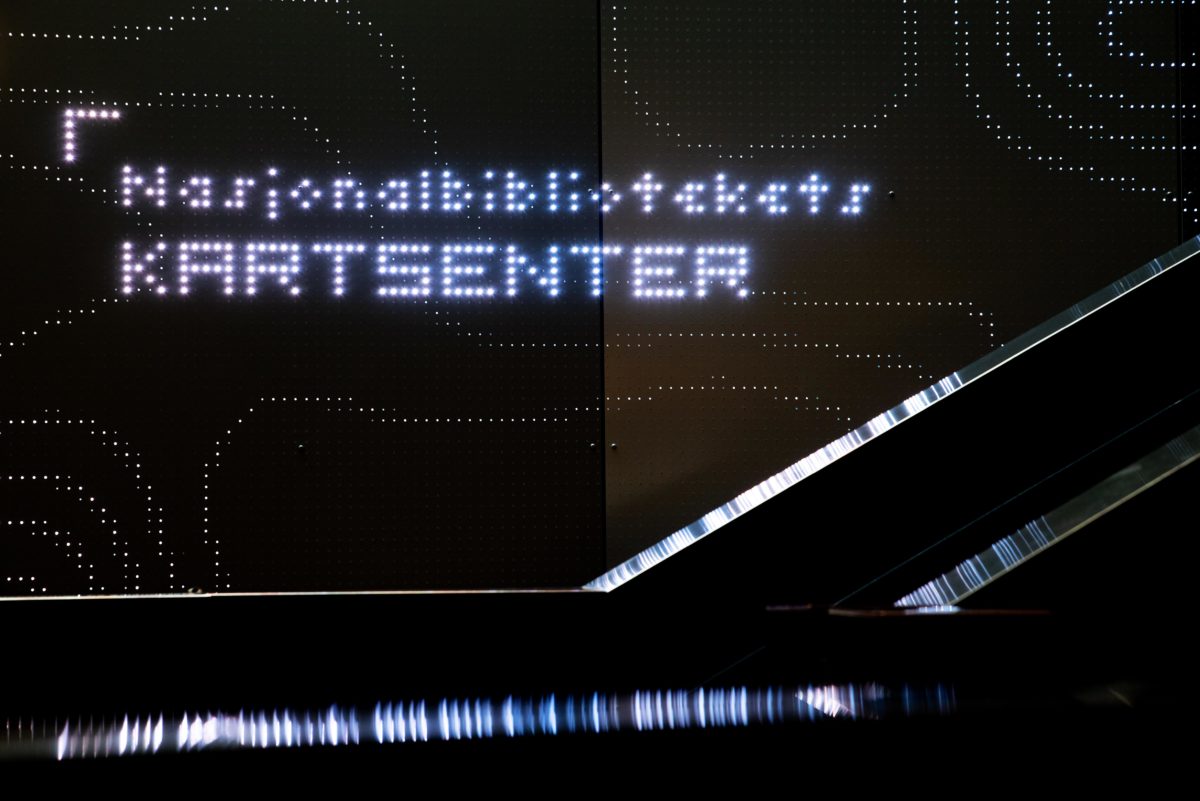Fotografi. Lysskilt med tittelen Nasjonalbibliotekets kartsenter.