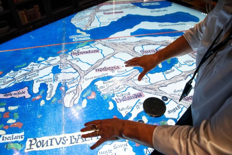 To hender navigerer over et større digitalt kart i blått og hvitt.