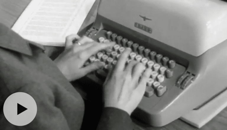 Sort/hvitt nærbilde av en kvinnes hender som skriver på en skrivemaskin.