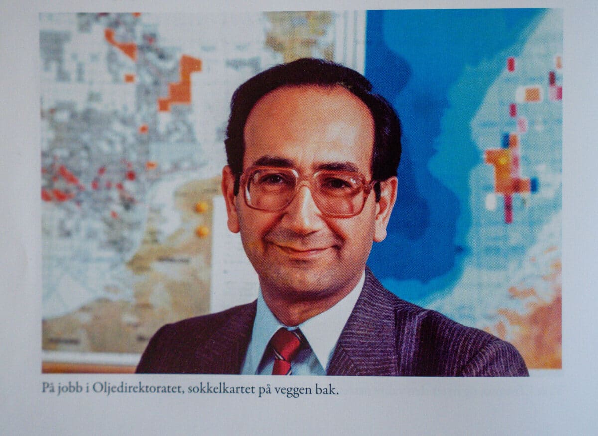 Farouk Al-Kasim som ung på jobb i Oljedirektoratet. Store briller, dress, rødt slips. Fotografi av bok.