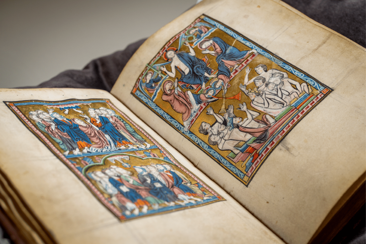 Kristina-psalteret fotografert ved det Kongelige Bibliotek i København. Gammel bok med fargerike illuminasjoner av av hvite mennesker i kjortler i blått og ferskenfarget.