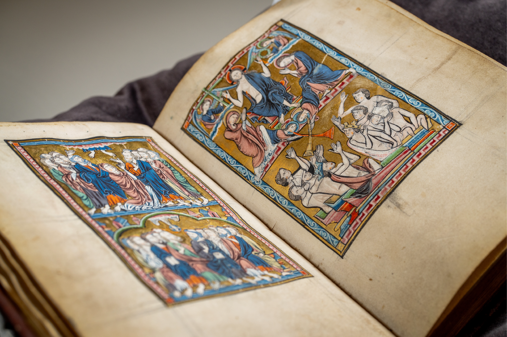 Kristina-psalteret fotografert ved det Kongelige Bibliotek i København. Gammel bok med fargerike illuminasjoner av av hvite mennesker i kjortler i blått og ferskenfarget.