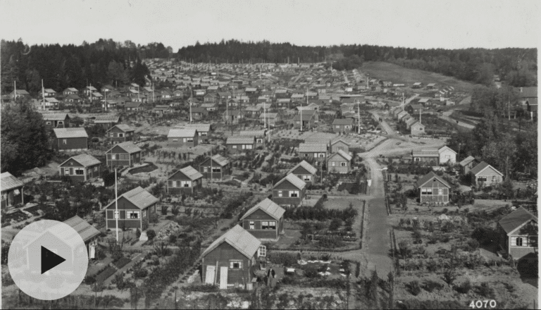 Svart-hvitt oversiktsbilde fra ca 1930 av en hageby med mange små hytter og hageparseller.