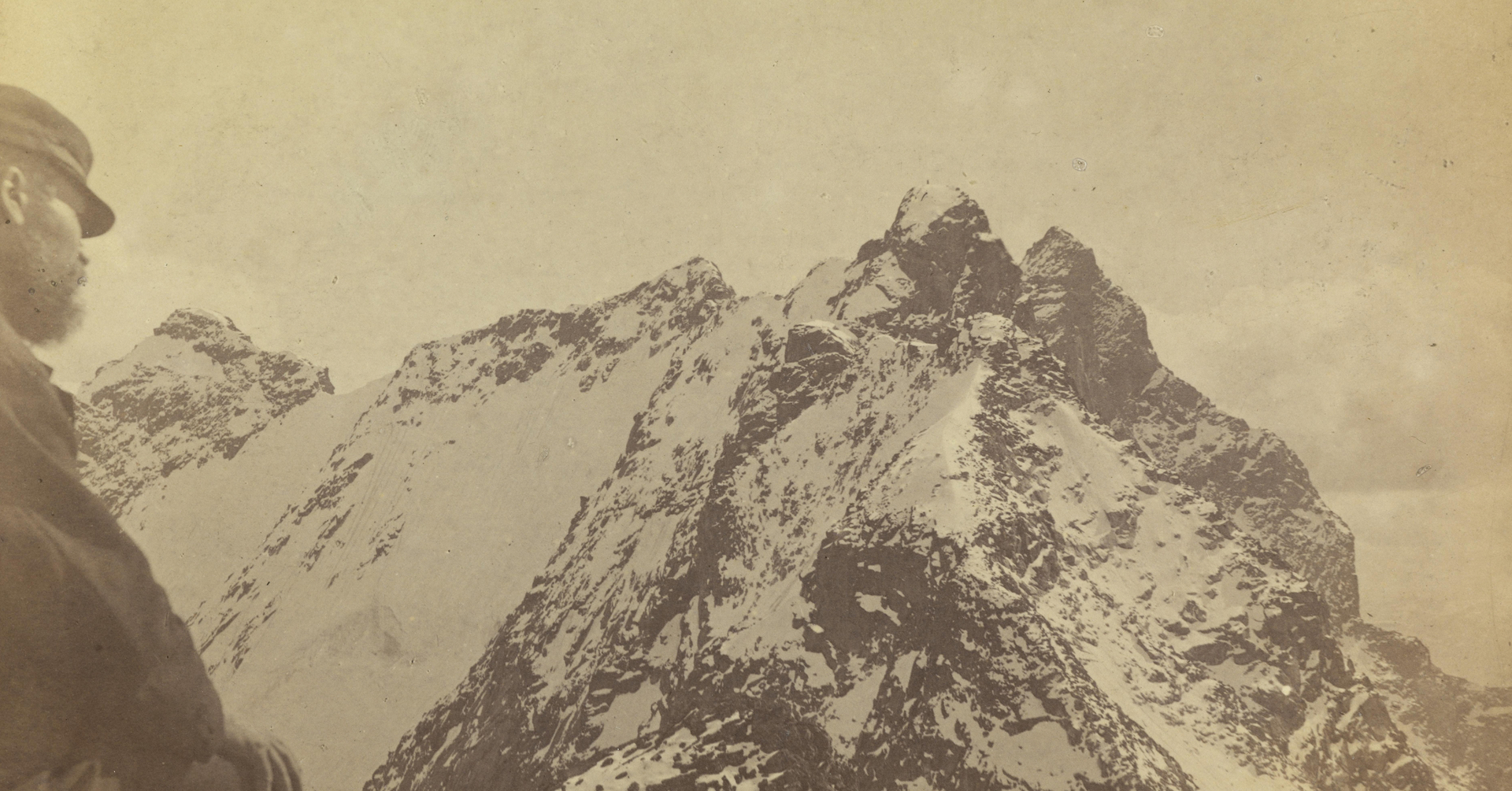 En mann ser ut mot en fjelltopp, dekt av snø